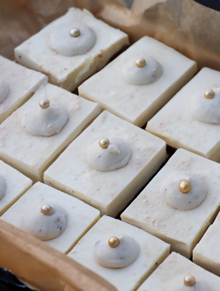 Mehrere geschnittene Stücke No-Bake Vanille-Cheesecake mit cremiger Frischkäsefüllung, echter Vanille und knusprigem Keks-Nuss-Boden mit Kokosraspeln, perfekt für schnelle und einfache Desserts